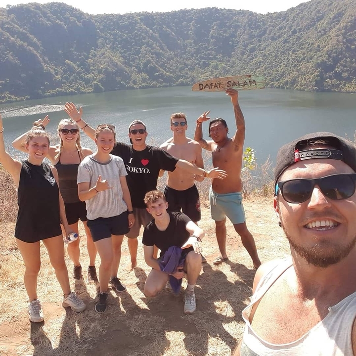 Group of people posing with an explorer sign by a lake