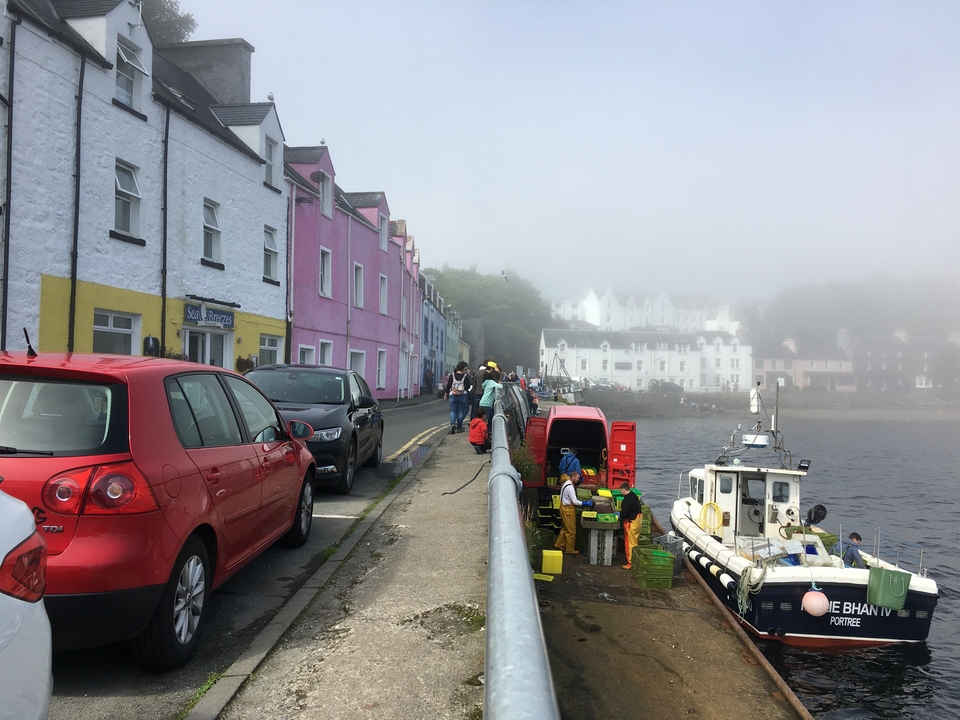Colorful buildings along a waterfront street with people.