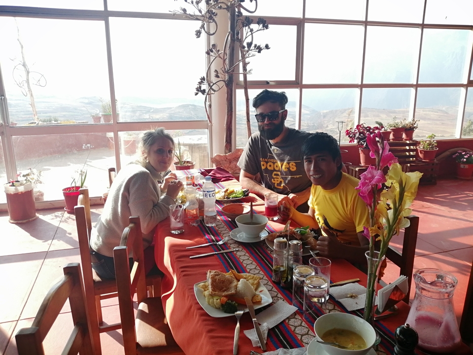 Trois personnes savourant un repas à une table avec vue.