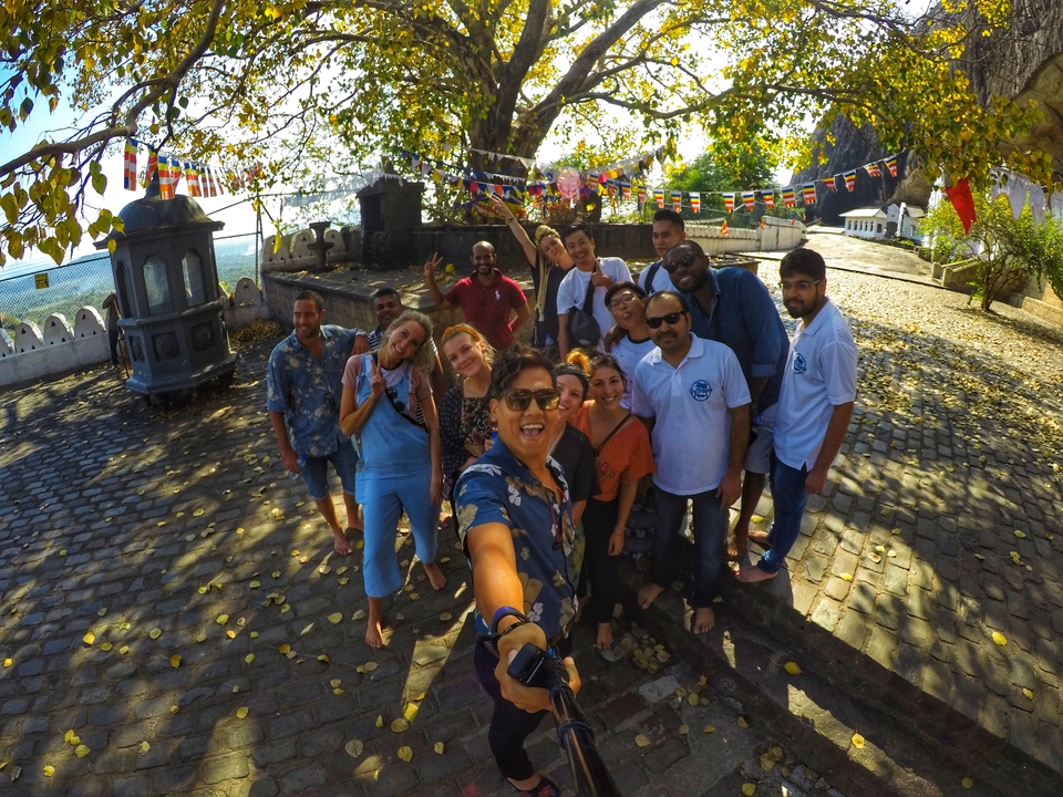Group selfie of travelers posing in a scenic outdoor setting.