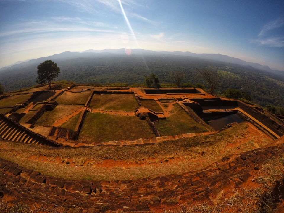 View of a historical site with flat areas and mountains in the distance.