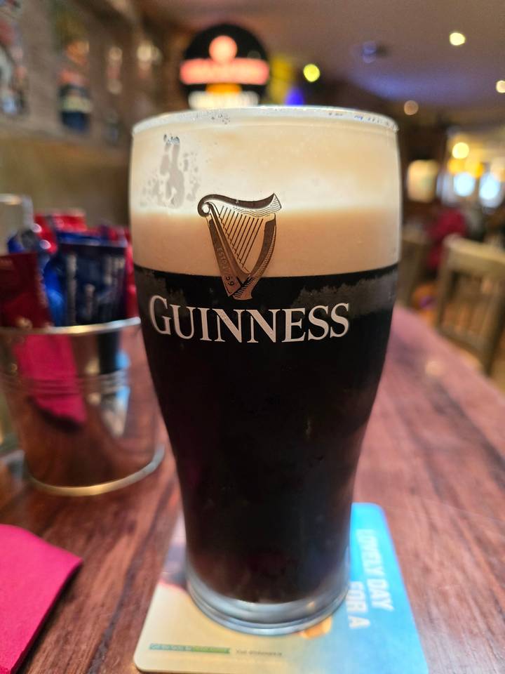 A pint of Guinness on a ledge inside a pub.