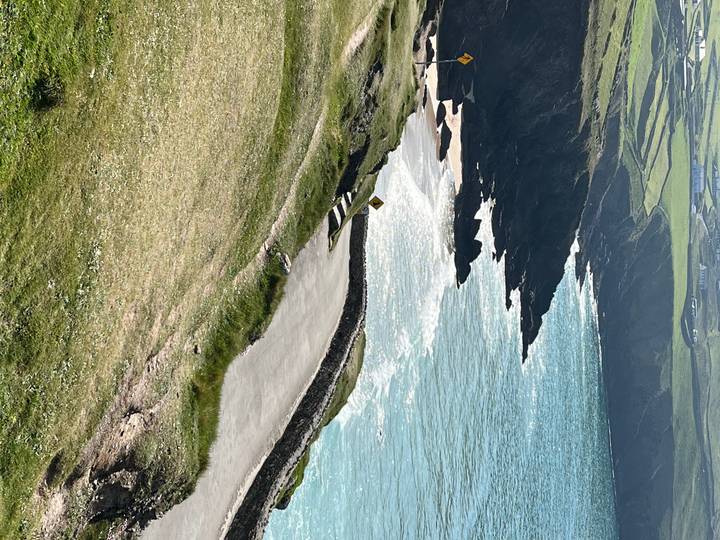 Coastal road with cliffs and blue ocean.