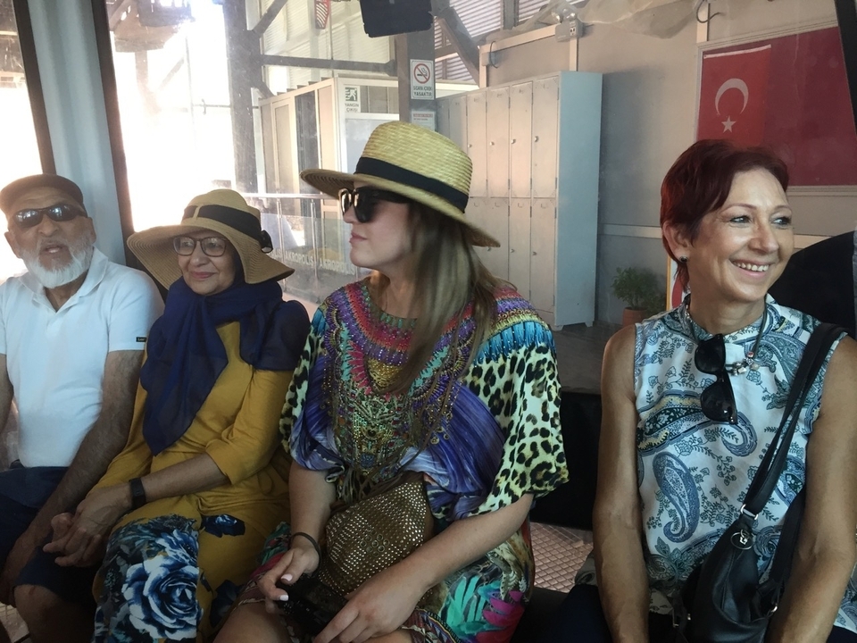 Group of people sitting together wearing hats.