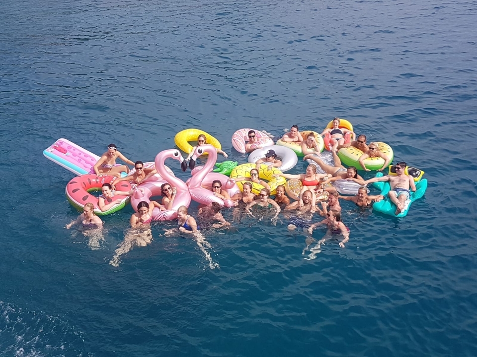 Groupe de personnes flottant sur des matelas pneumatiques colorés dans la mer.