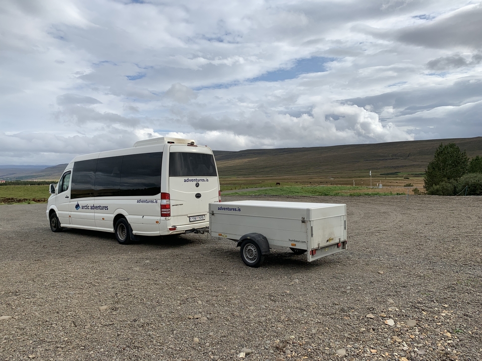 Van with a trailer in an open area.