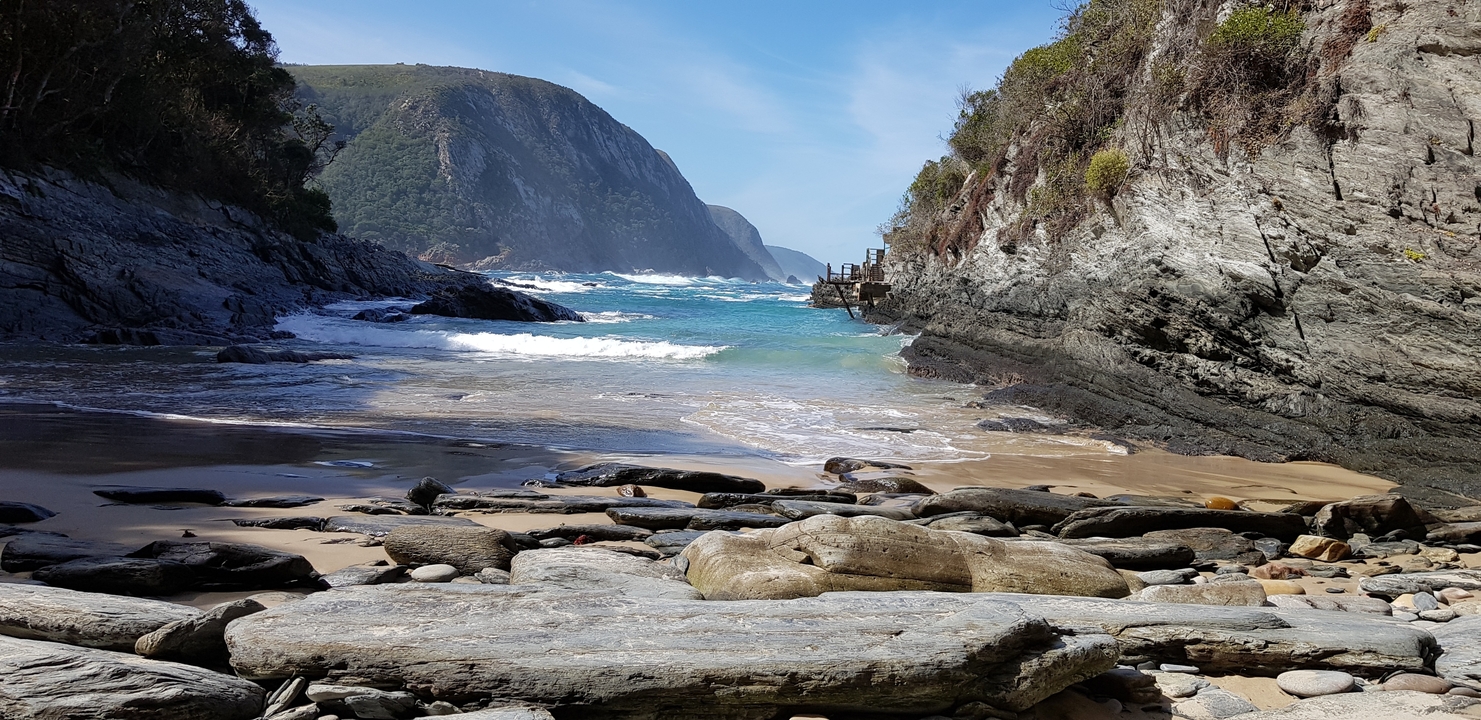 Vue pittoresque d'une crique rocheuse avec des vagues qui se brisent contre le rivage.