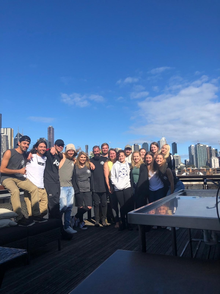 Un groupe de personnes posant sur un toit avec un horizon urbain en arrière-plan.