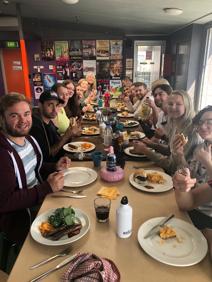 Un groupe de personnes qui profitent d'un repas ensemble à une longue table.