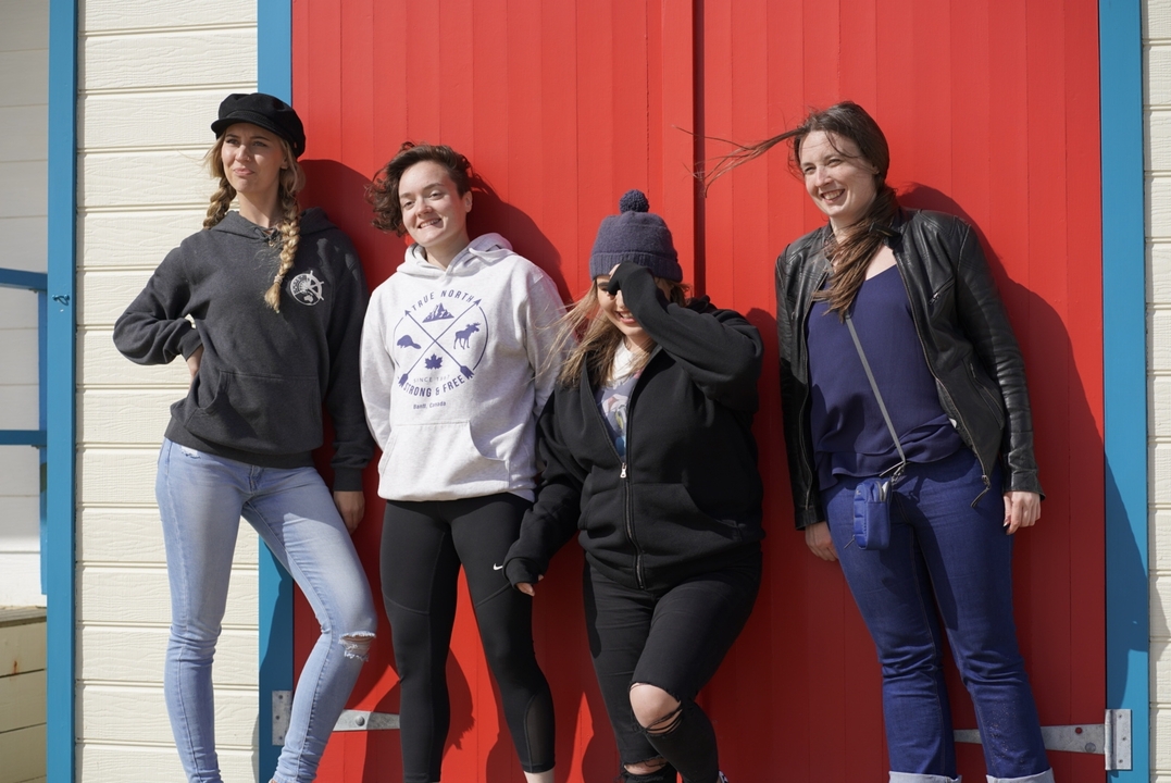 Groupe de personnes posant devant des portes colorées.