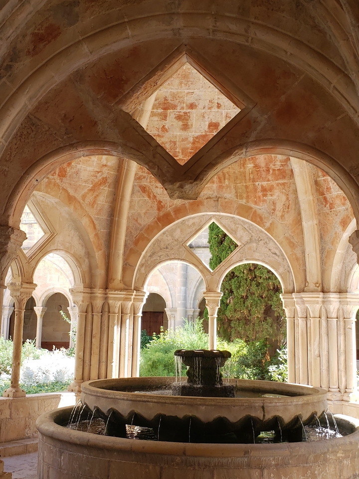Arches et colonnes historiques avec la lumière du soleil illuminant la pierre.