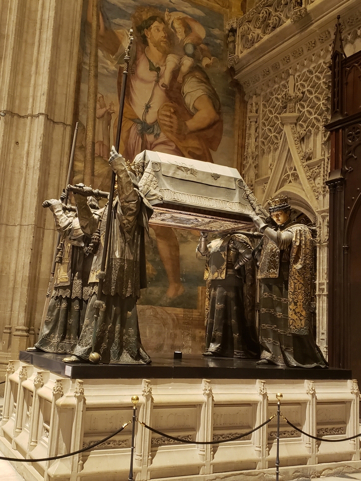 Sculptures décoratives soutenant un grand cercueil à l'intérieur.