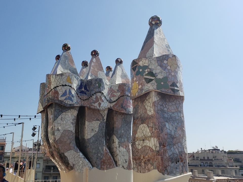 Structures de mosaïque décoratives sur un toit avec un ciel bleu en arrière-plan.