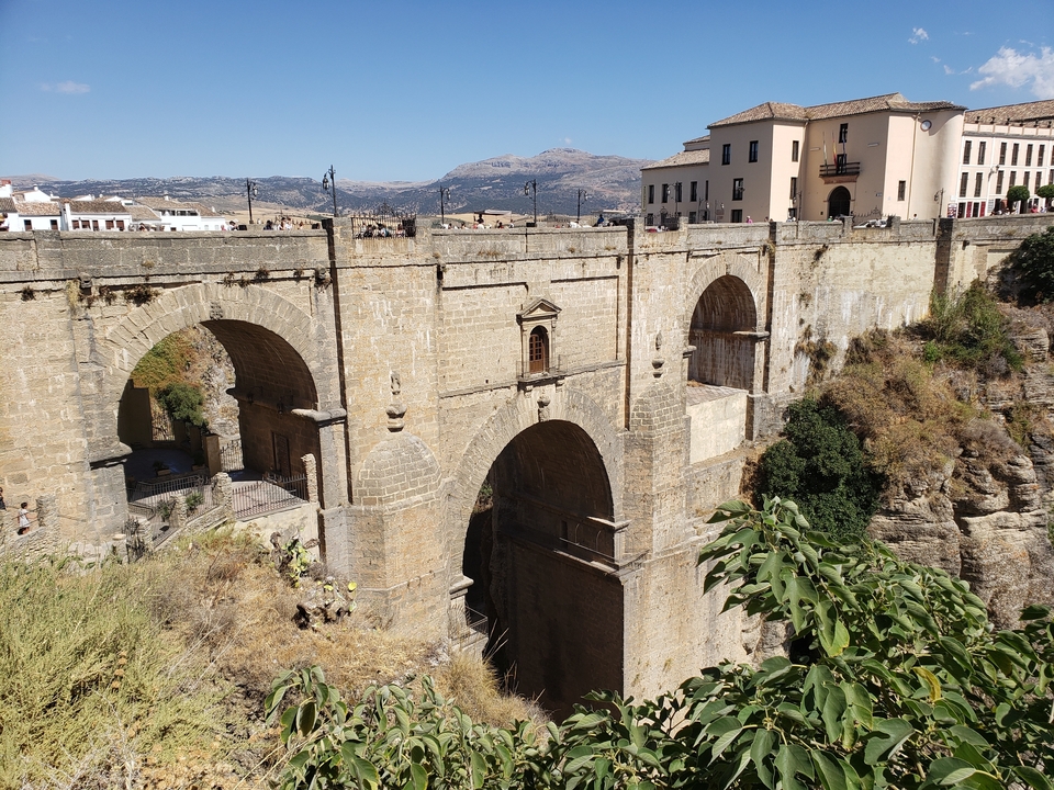 Pont de pierre historique enjambant une gorge profonde.