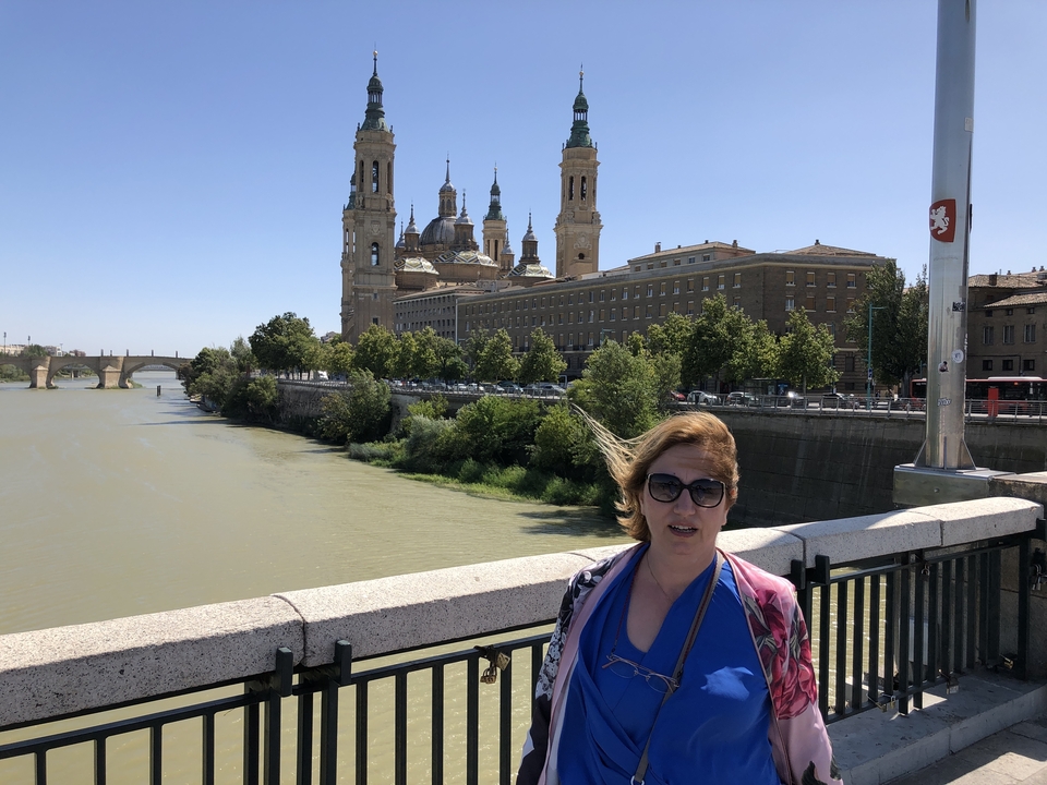 Personne debout près d'une rivière avec une cathédrale en arrière-plan.