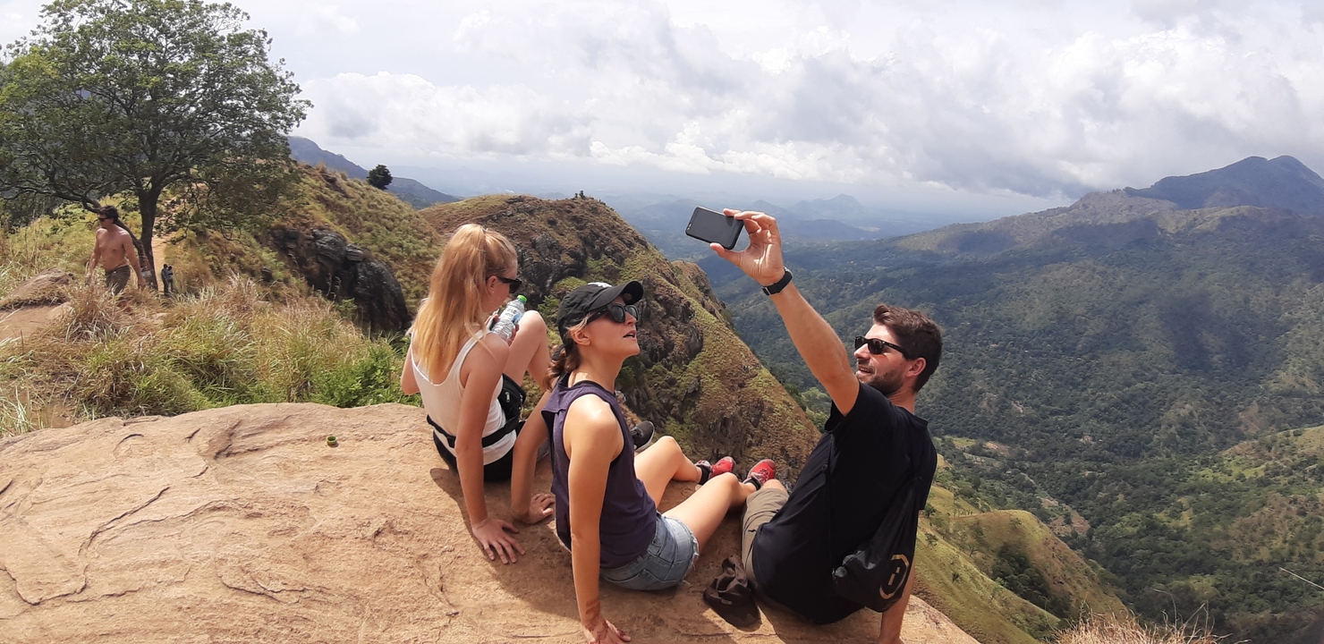Group of people taking a selfie on a mountain cliff.