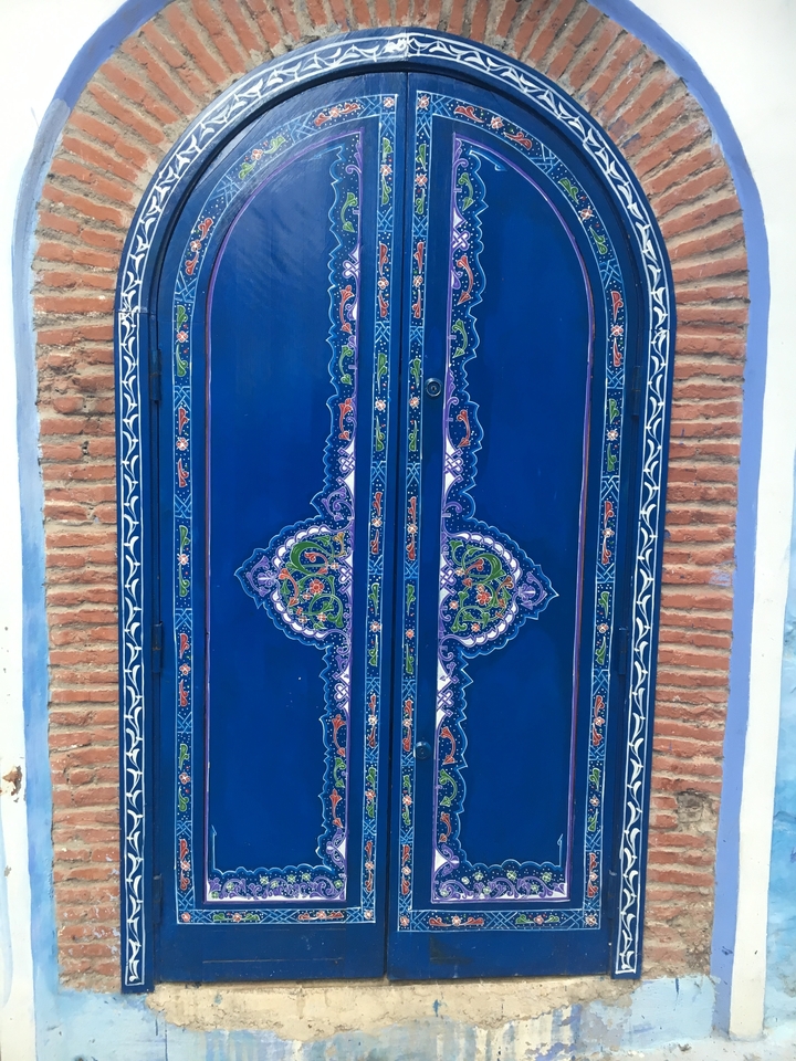 A vibrant blue door with intricate designs.