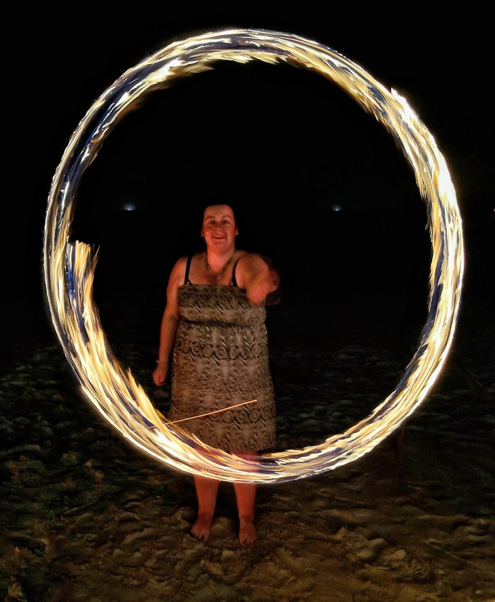 Person performing fire dancing at night.
