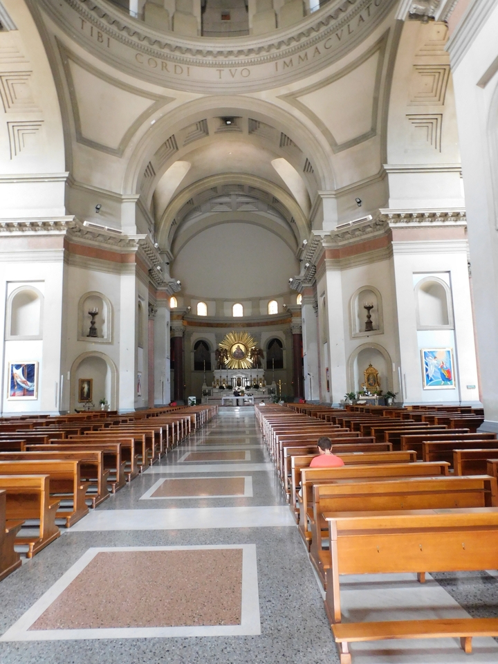 Interior of a church with pews and an ornate altar.