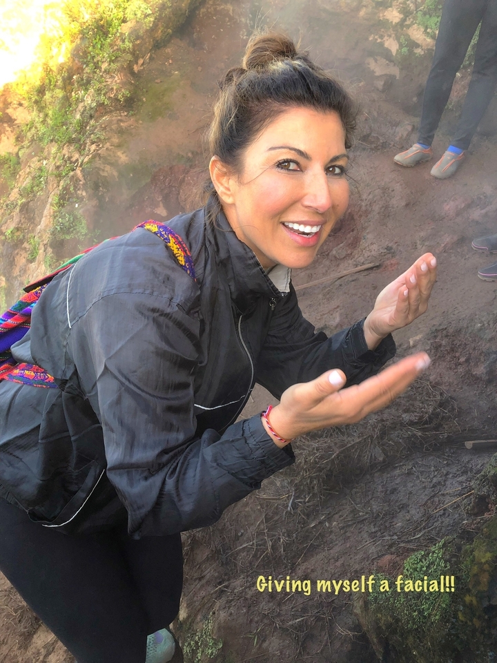 Une personne souriante penchée au-dessus d'un terrain rocheux