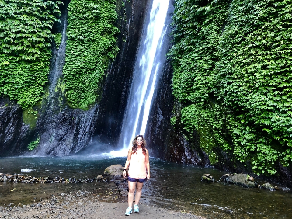 Femme posant devant une cascade