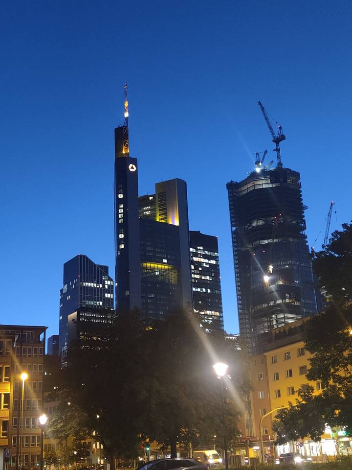 Gratte-ciel modernes et grues au crépuscule.