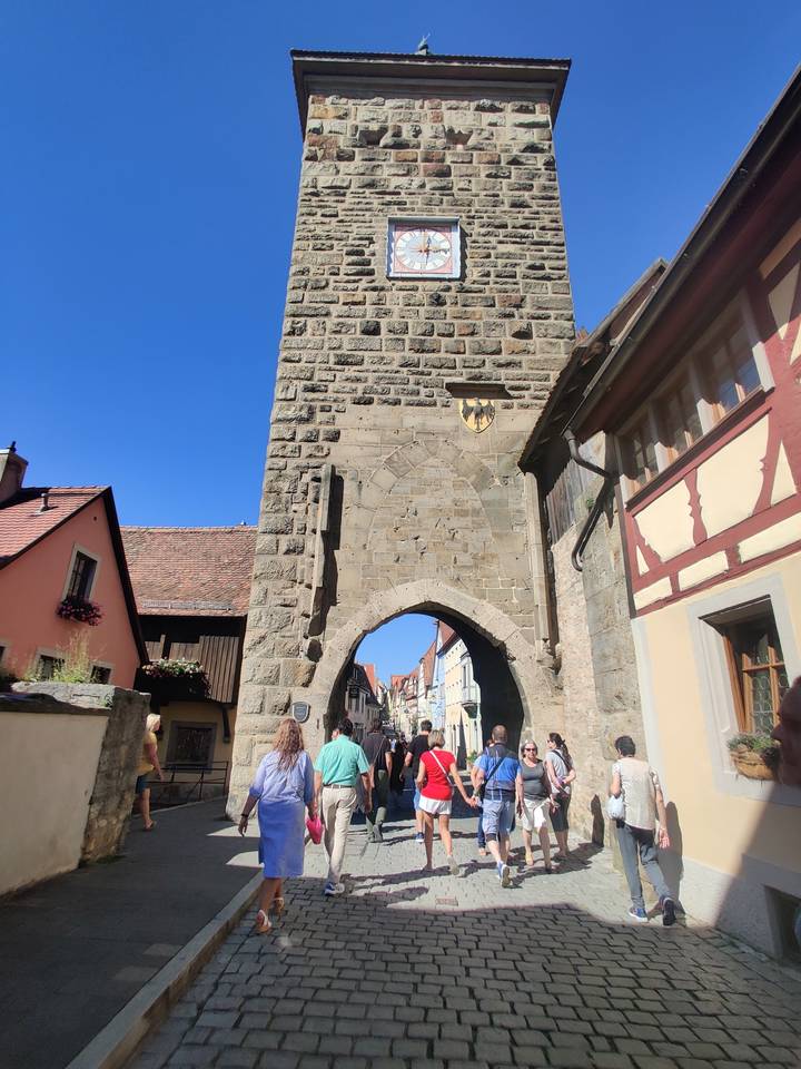 Porte fortifiée avec des touristes qui passent.