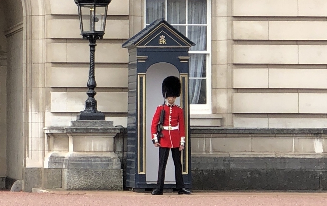 Guard in traditional uniform outside a royal building.