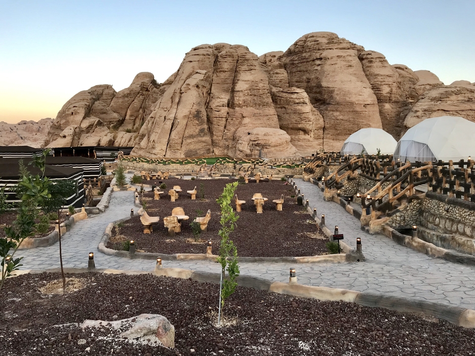 Outdoor seating at a campsite against rocky mountain background.