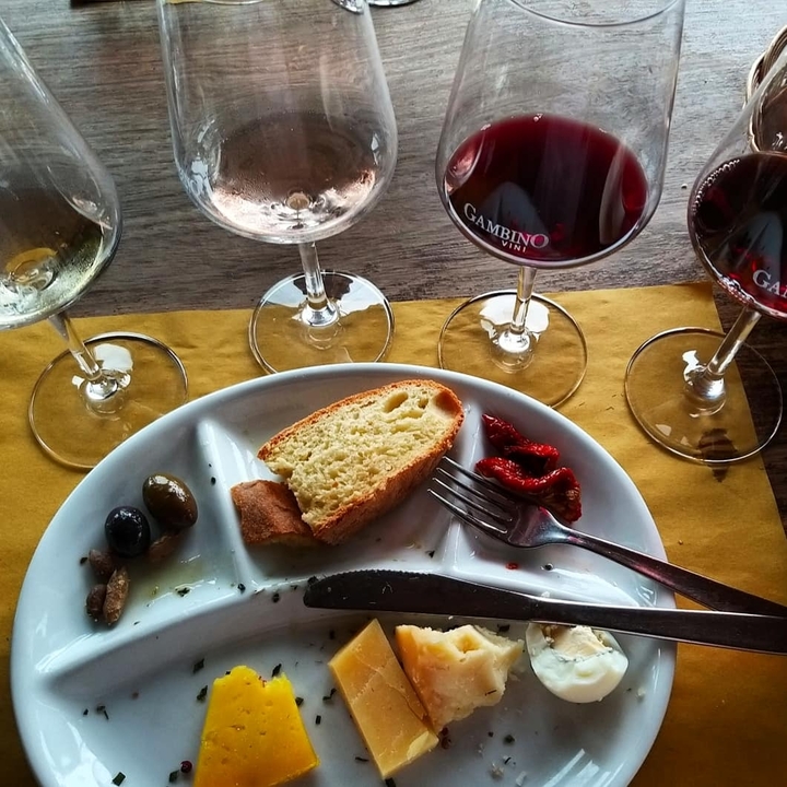 Plate of snacks with three glasses of wine.