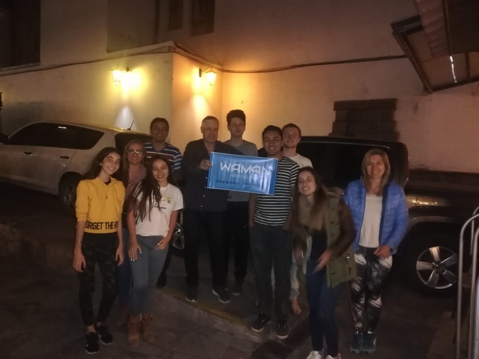 Group photo taken at night with a banner.