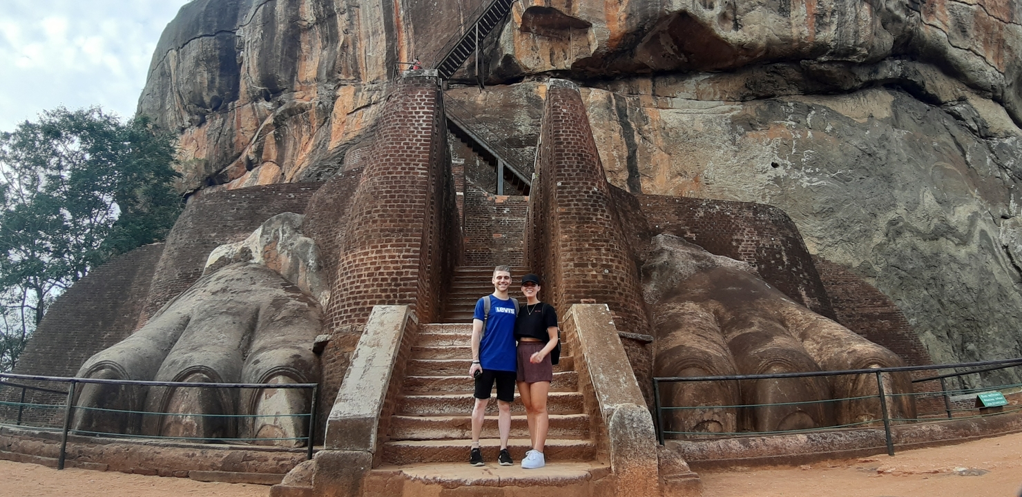 Couple standing at the base of the Lion Rock Fortress.