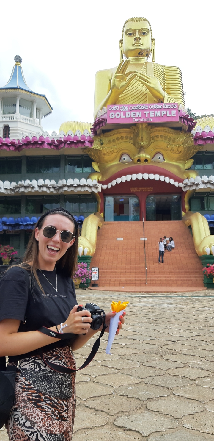 Woman posing in front of a colorful Buddhist museum.