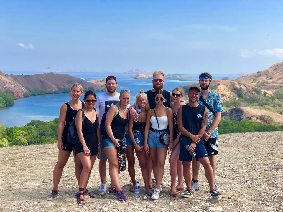 Groupe de personnes posant avec un arrière-plan pittoresque.