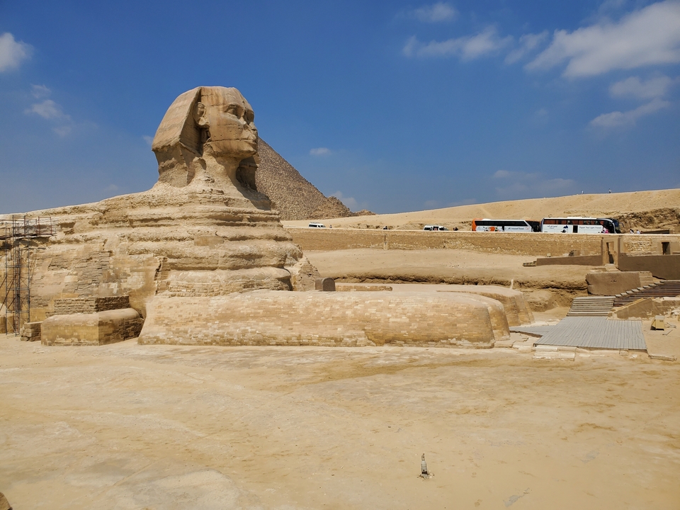 The Sphinx with a pyramid in the background.