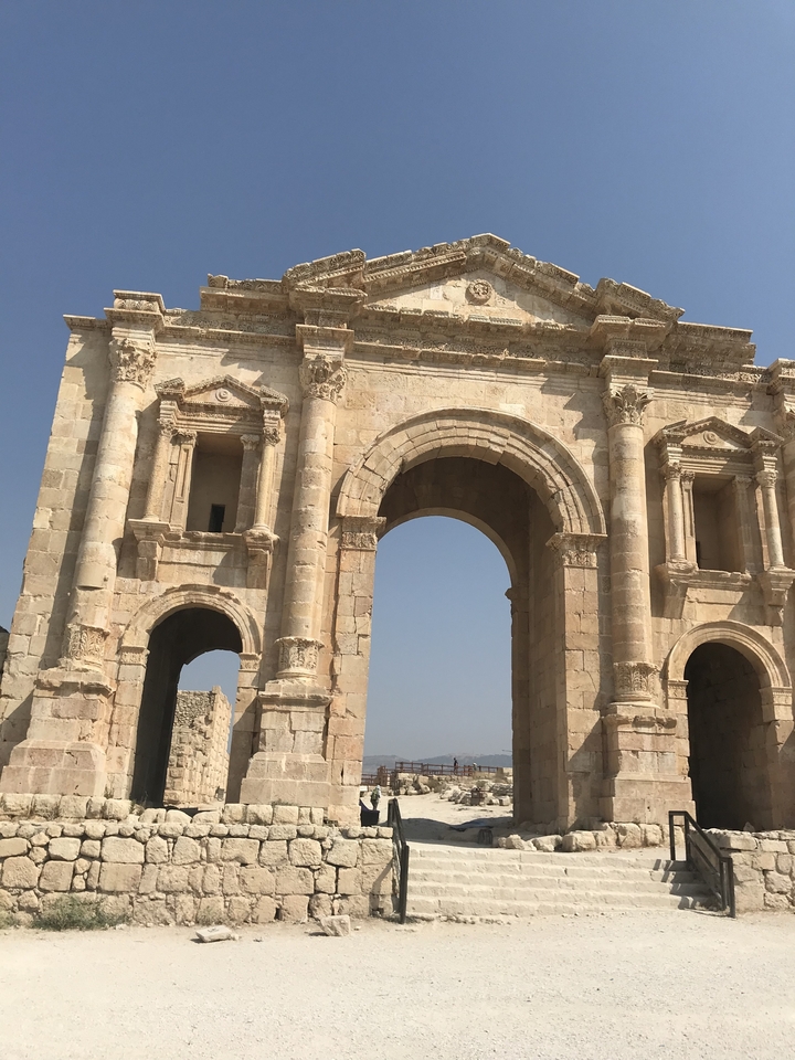 Arche de pierre ancienne sous un soleil éclatant.