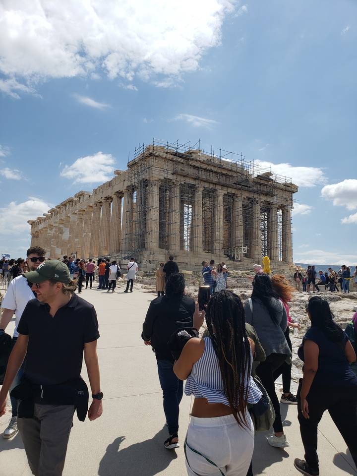 The Parthenon with scaffolding and tourists around.