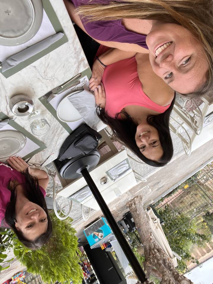 Three people dining at an outdoor restaurant.