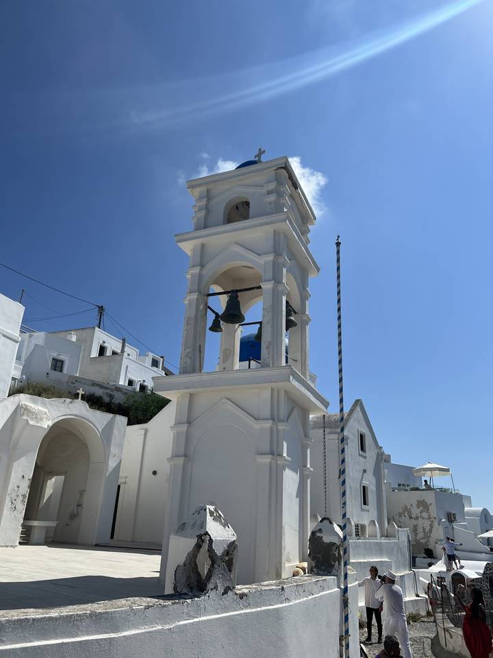 Bell tower of a white church against a blue sky.