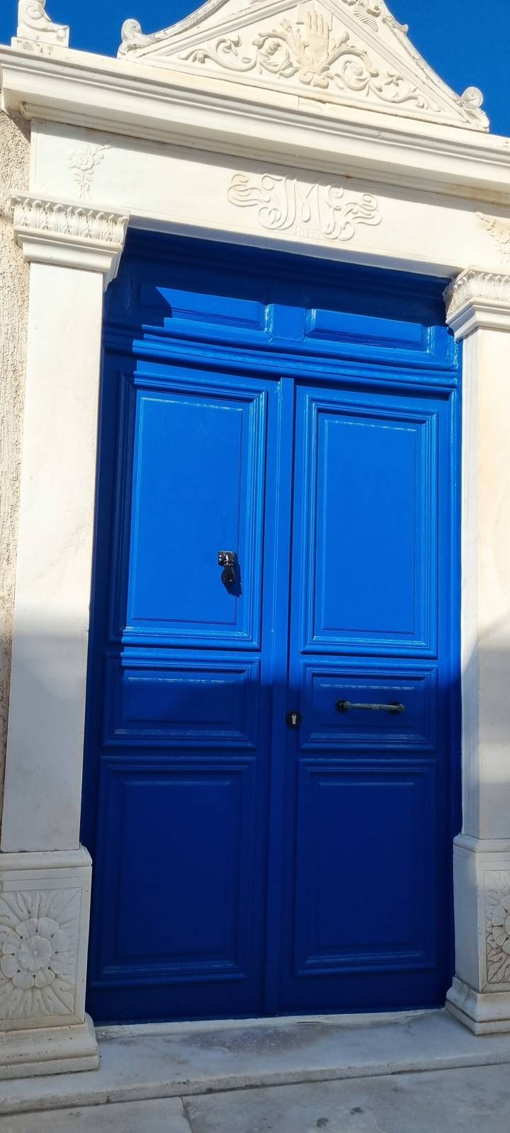 Bright blue door set in a white building.