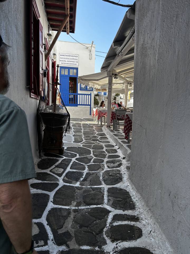 Traditional narrow street with stone paving and shops.