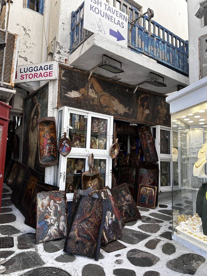 Small shop displaying various paintings and items on the street.