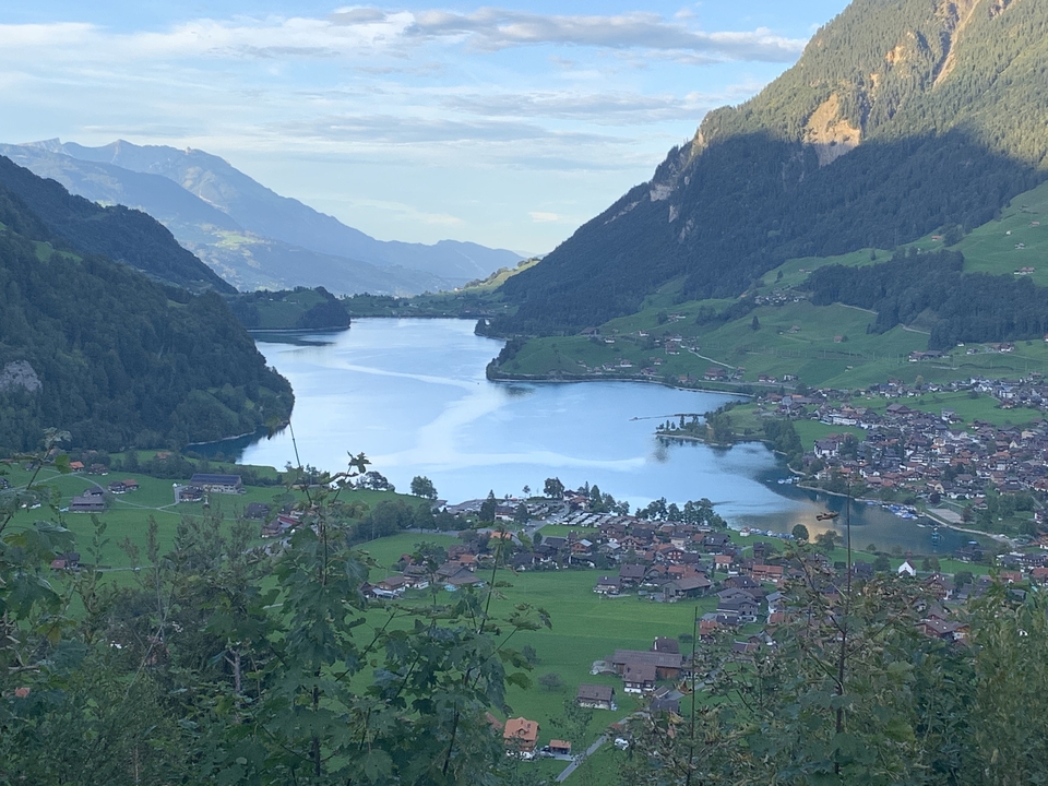 Vue panoramique d'un lac avec de petites villes et des montagnes.
