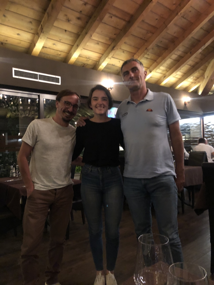 Trois personnes debout ensemble à l'intérieur.