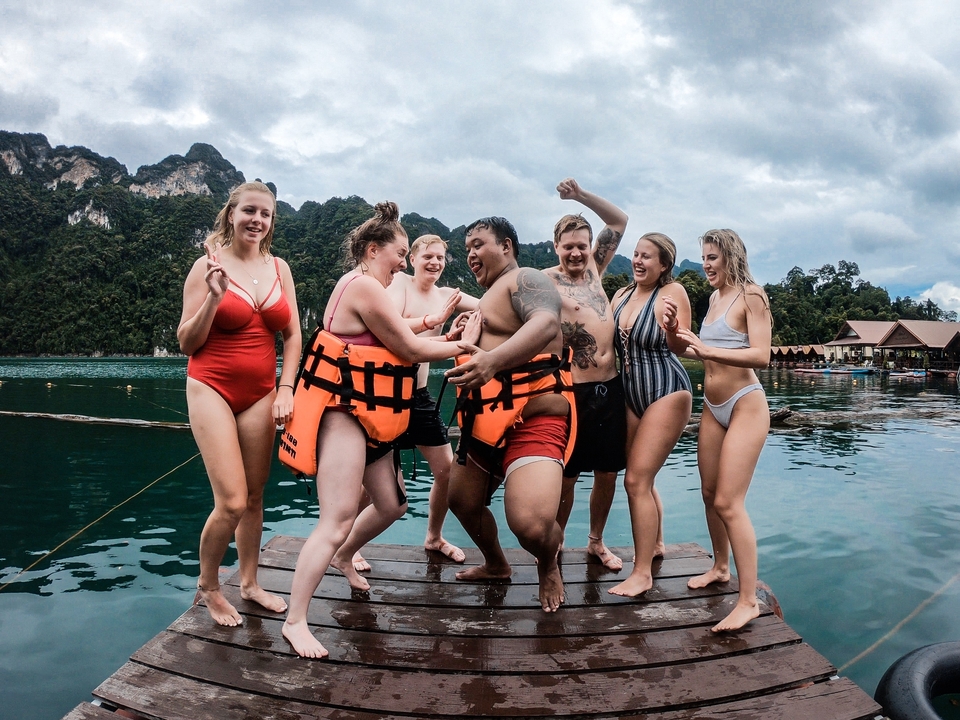 Group of people laughing and enjoying time together on a dock.