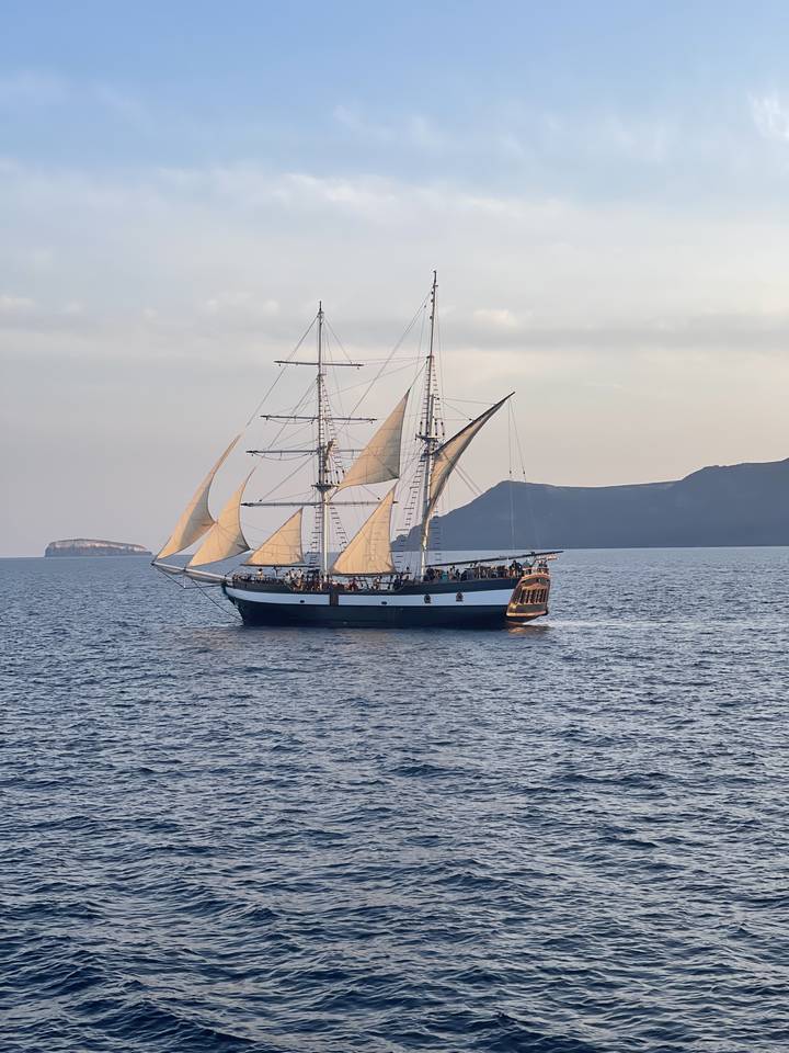 Sailing ship on the ocean with sails unfurled.