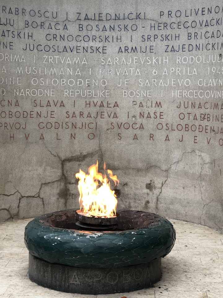 Une flamme devant un mur avec des inscriptions.