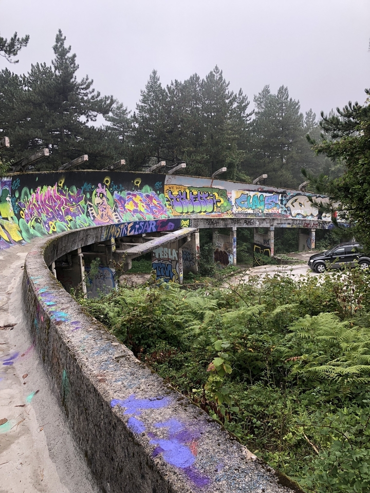 Piste de bobsleigh abandonnée avec graffitis.