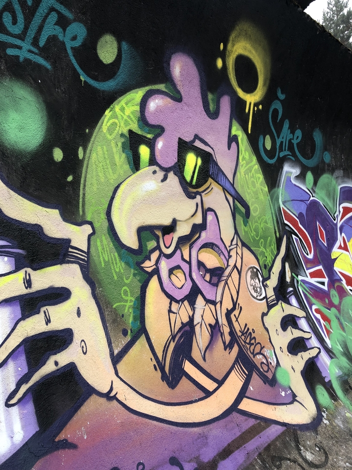 Art de graffiti représentant un personnage portant des lunettes.