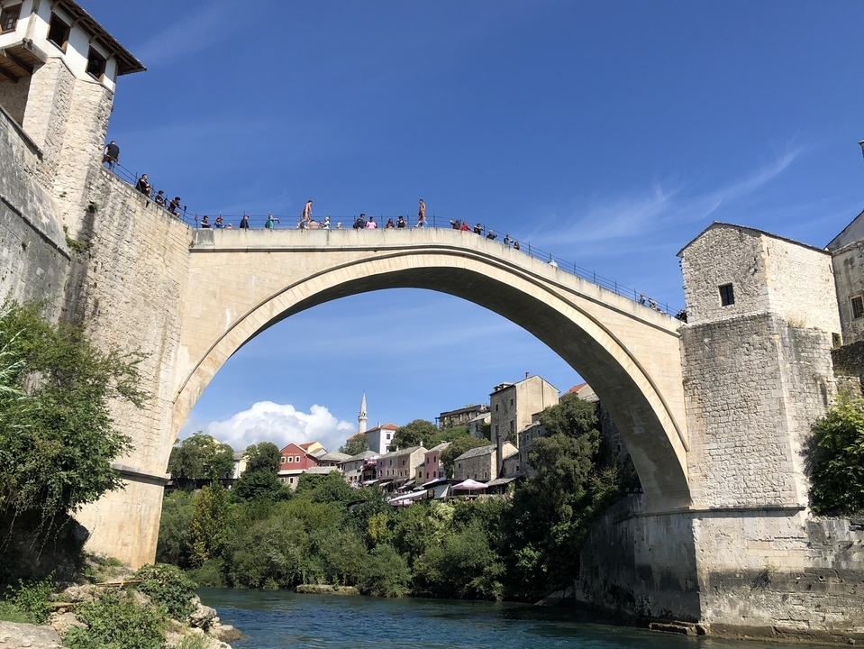 Pont célèbre avec des gens qui marchent dessus et une ville pittoresque en arrière-plan.